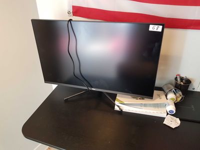 un écran d'ordinateur posé sur un bureau, à côté d'un ordinateur portable
