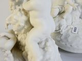 a white statue of a woman holding a baby