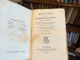 une personne tenant un livre à la main devant une bibliothèque