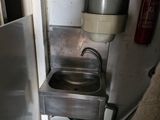 a small kitchen with a sink and a lot of rolls of toilet paper