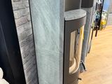 a stove in the middle of a room next to a wall