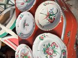 de nombreuses assiettes et bols posés sur une table recouverte d'une nappe rouge