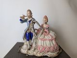 a figurine of a man and a woman playing a musical instrument