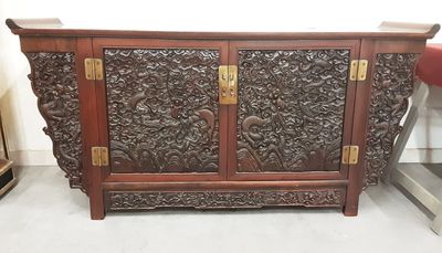 une armoire en bois dont les portes et les tiroirs sont sculptés