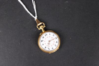 une petite montre de poche en or avec une chaîne, posée sur une surface noire