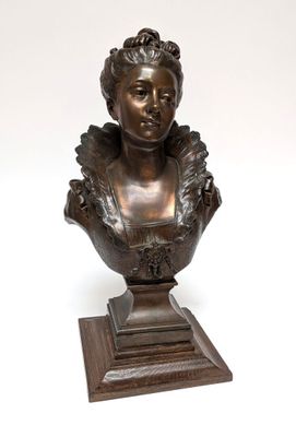 an antique bronze bust of a woman on a wooden base