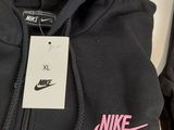 a close up of a black hoodie with a pink nike logo on it