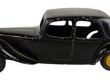 une petite voiture noire aux roues jaunes sur fond blanc