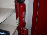 a red fire extinguisor sitting on a shelf in a room