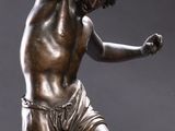 bronze statue of a man holding a tennis racquet on a marble base