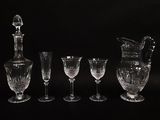 five wine glasses and a decanter on a black background