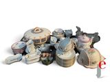 une pile d'assiettes et de tasses en porcelaine posée sur une surface blanche