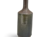 a brown and green vase sitting on a white surface