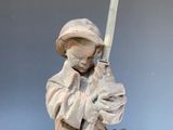statue of a boy with a sword and a hat