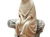 a statue of a boy sitting on top of a rock