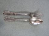 two forks and a spoon sitting on a table