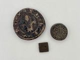 un gros plan d'une pièce de monnaie et d'une petite pièce posées sur une surface blanche