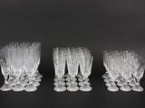 four clear wine glasses sitting on top of a black table