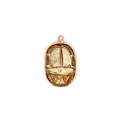 gros plan d'un pendentif en or sur fond blanc