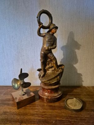 une statue représentant un homme coiffé d'un chapeau, posée sur une table