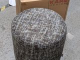 a small round ottoman sitting on the floor next to a box