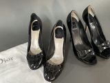 three pairs of black shoes sitting on top of a white bag