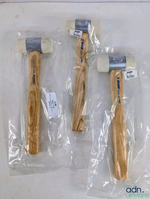 trois marteaux à manche en bois sont emballés dans des sacs en plastique sur une table