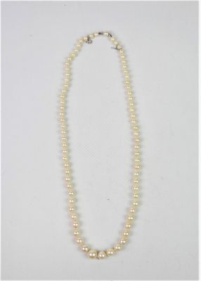 un collier de perles blanches avec un fermoir en argent sur fond blanc
