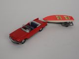 une petite voiture avec une planche de surf à l'arrière