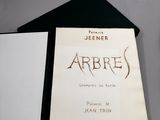 un livre en noir et blanc posé sur une table, à côté d'une paire de ciseaux