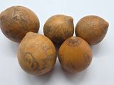 quatre boules en bois ornées de motifs, posées sur une surface blanche