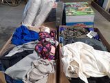 many boxes of clothes on a table outside of a store