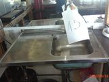 a metal sink with a sign on it in a kitchen