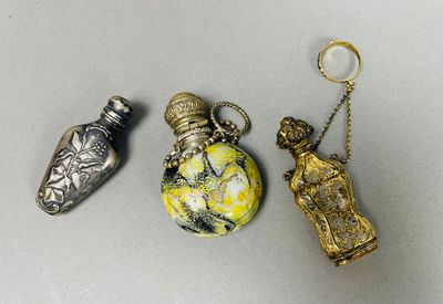 trois flacons de parfum miniatures sont posés les uns à côté des autres sur une table