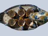 a blue and white fish shaped dish with chocolates in it