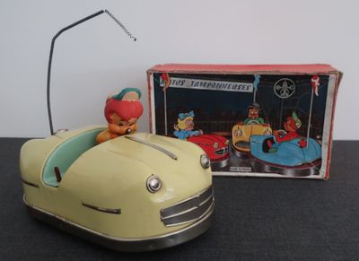 une petite voiture avec un clown à l'intérieur, à côté d'une boîte de jouets