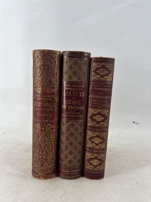three old books sitting on top of each other on a white surface