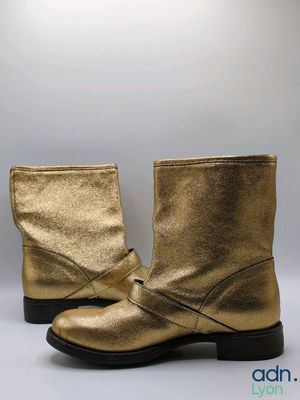 a close up of a pair of gold boots on a white background