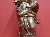 une statue représentant une femme tenant un oiseau, posée sur une table