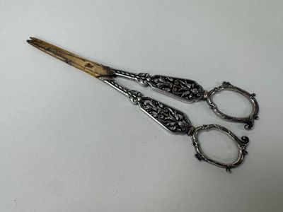 a pair of scissors sitting on a white surface