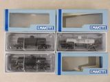 trois cartons contenant des trains miniatures posés sur une table