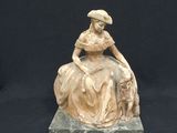 statue of a woman sitting on a rock with a dog