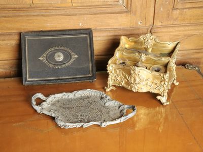 une photo représentant une assiette en or et une boîte noire posées sur une table en bois
