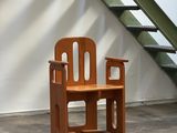 a wooden chair that is sitting in front of a staircase