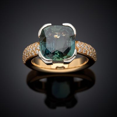 a close up of a ring with a blue diamond on a black surface