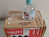 un flacon de gel hydroalcoolique posé sur une boîte