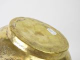 a gold vase with a lid sitting on a table