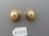 two pairs of gold and pearl earrings with a price tag