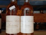 deux bouteilles de vin posées sur une étagère l'une à côté de l'autre