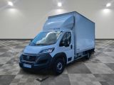Le camion blanc est garé sur un sol à damier dans une pièce.